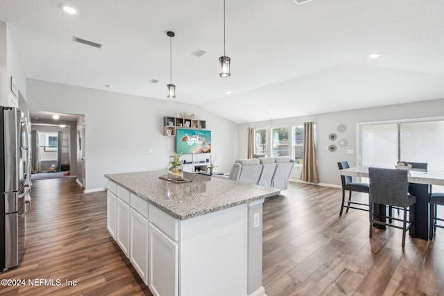 kitchen featuring light stone countertops, hanging light fixtures, white cabinetry, lofted ceiling, and dark wood-type flooring