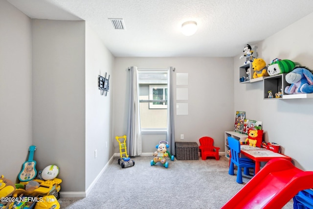 recreation room featuring carpet and a textured ceiling