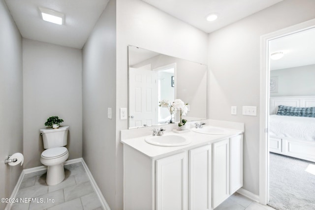 bathroom with toilet, vanity, and tile patterned flooring