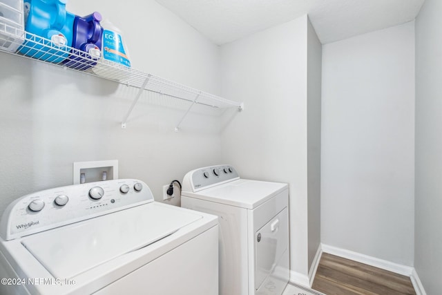 clothes washing area with independent washer and dryer and hardwood / wood-style flooring