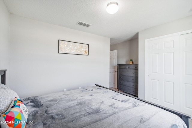 bedroom with a textured ceiling and a closet