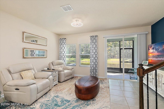 living room with light tile patterned flooring and a textured ceiling