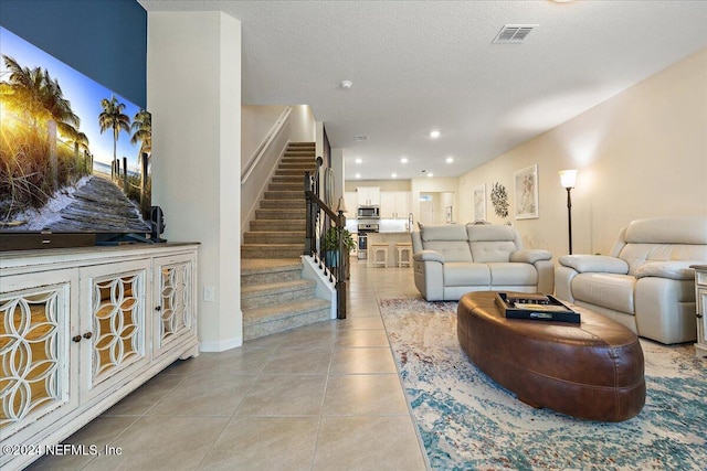 living room featuring a textured ceiling and light tile patterned floors