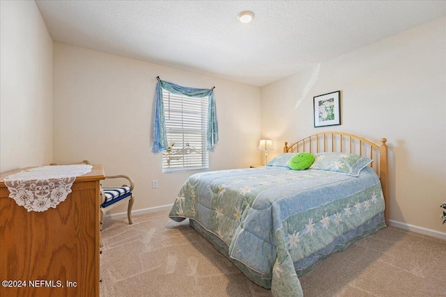 bedroom featuring a textured ceiling and light colored carpet