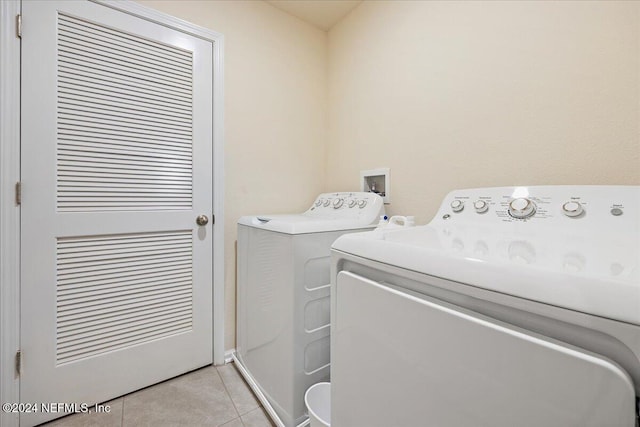 laundry room with washing machine and clothes dryer and light tile patterned floors