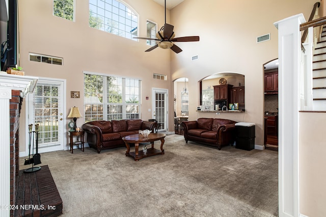 living room featuring light carpet, a high ceiling, and ceiling fan