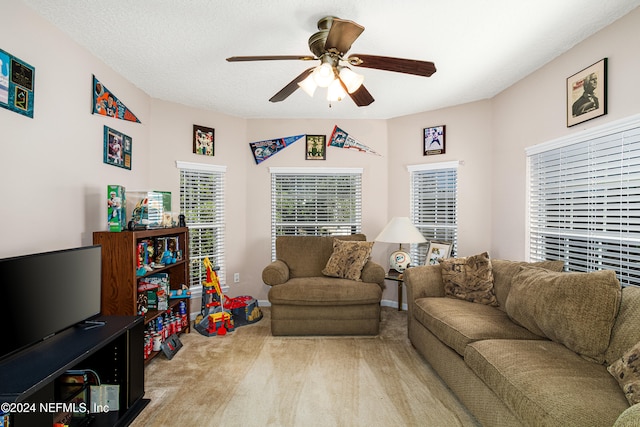 carpeted living room with a textured ceiling and ceiling fan