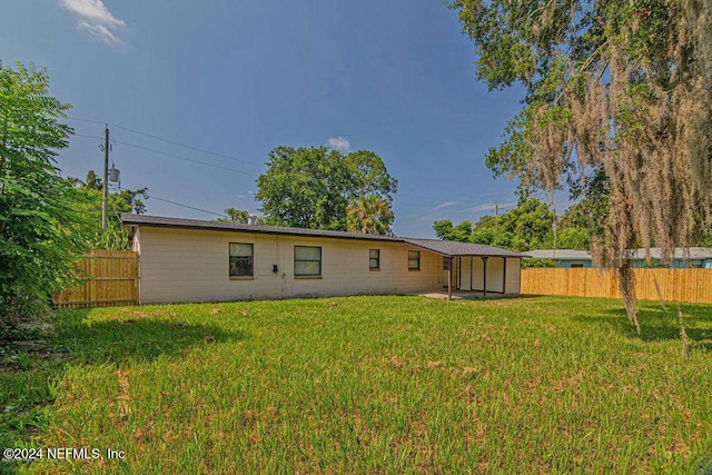 rear view of property with a lawn