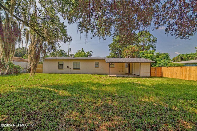 rear view of property featuring a patio and a lawn