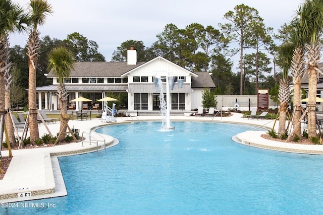 community pool with a patio area and fence