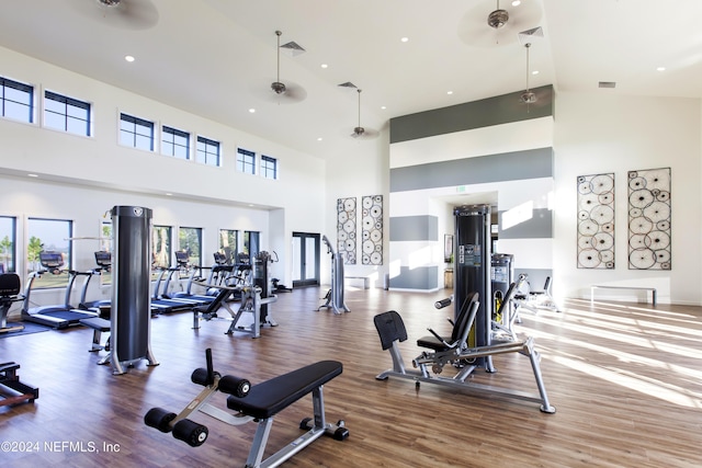 gym featuring recessed lighting, a high ceiling, visible vents, and wood finished floors