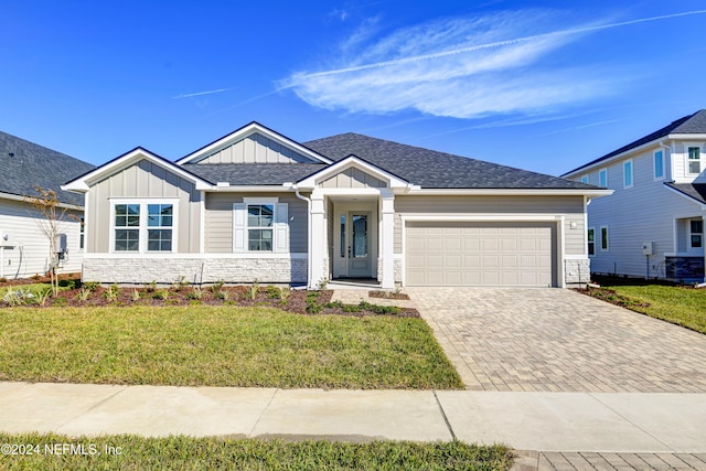 view of front of home with a garage and a front lawn