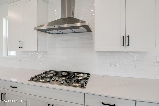 2523 Trailmark Dr, Saint Augustine, FL 32092 - kitchen with white cabinetry, stainless steel gas stovetop, ventilation hood, and backsplash