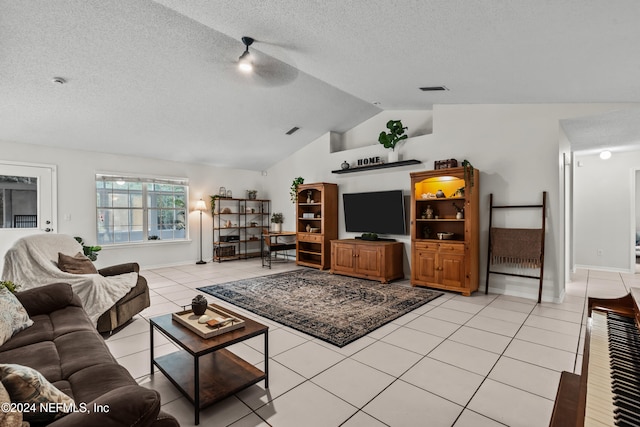 living room featuring ceiling fan, a textured ceiling, light tile patterned floors, and vaulted ceiling