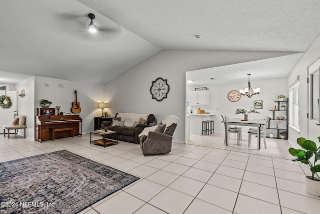 living room with a textured ceiling, vaulted ceiling, light tile patterned floors, and ceiling fan with notable chandelier