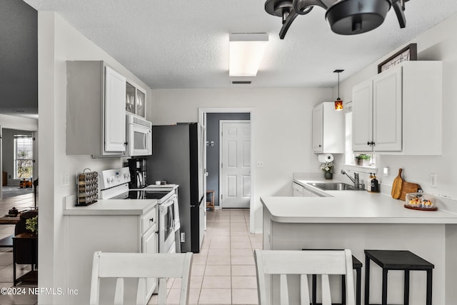 kitchen with white cabinets, kitchen peninsula, and white appliances