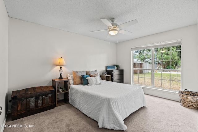 carpeted bedroom featuring a textured ceiling and ceiling fan