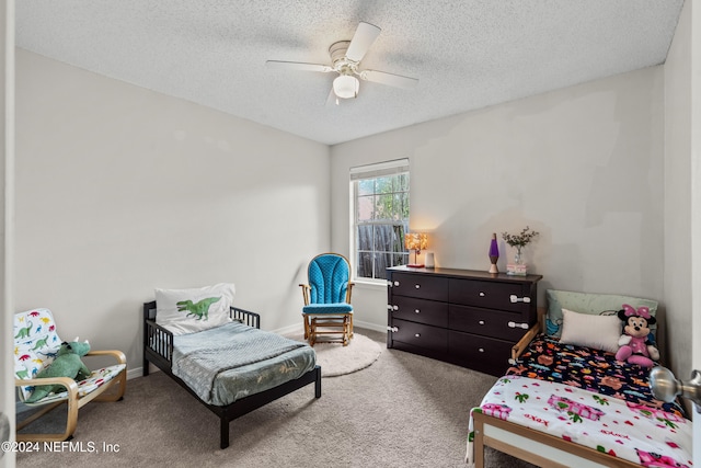 bedroom with a textured ceiling, carpet floors, and ceiling fan