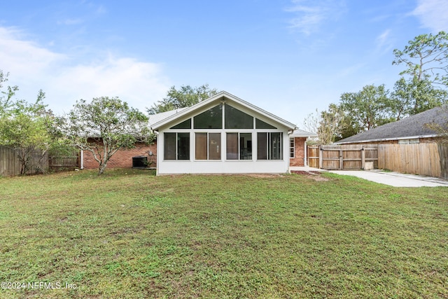 rear view of property featuring central air condition unit, a patio area, a sunroom, and a yard