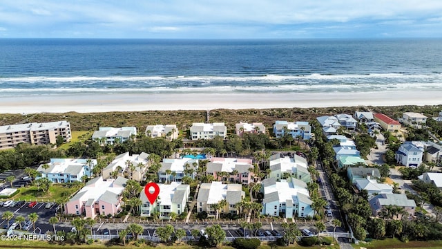 birds eye view of property featuring a water view and a beach view