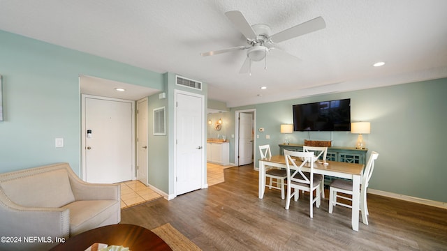 dining area with hardwood / wood-style flooring, ceiling fan, and a textured ceiling