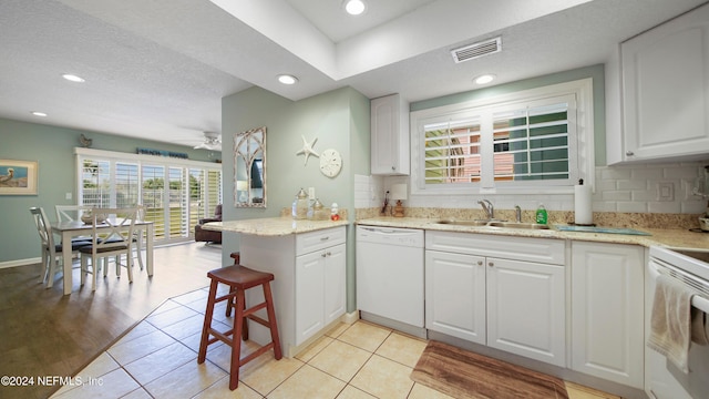 kitchen featuring kitchen peninsula, a textured ceiling, white appliances, sink, and white cabinetry