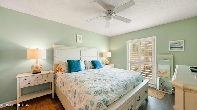 bedroom featuring a textured ceiling, ceiling fan, and dark hardwood / wood-style floors