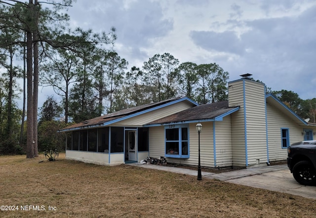 exterior space featuring a sunroom and a yard