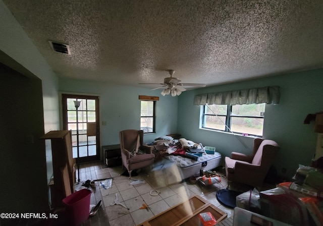 interior space featuring light tile patterned flooring, a textured ceiling, and ceiling fan