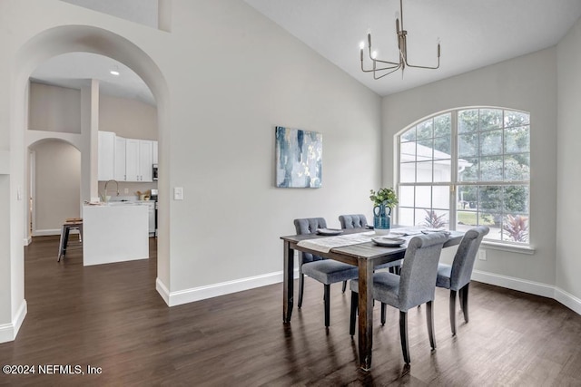 dining area with an inviting chandelier, dark hardwood / wood-style floors, high vaulted ceiling, and sink