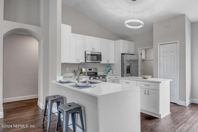 kitchen with hanging light fixtures, white cabinetry, kitchen peninsula, and stainless steel appliances