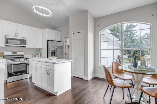 kitchen with a kitchen island, dark hardwood / wood-style flooring, stainless steel appliances, lofted ceiling, and white cabinets