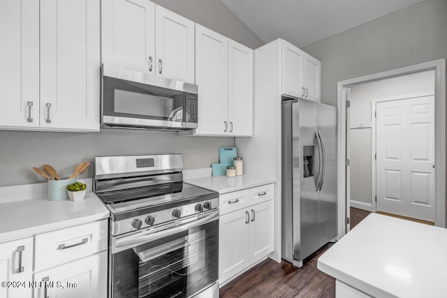 kitchen featuring appliances with stainless steel finishes, lofted ceiling, white cabinetry, and dark hardwood / wood-style flooring