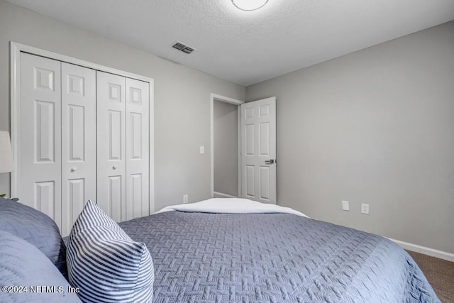 bedroom featuring a textured ceiling, carpet flooring, and a closet