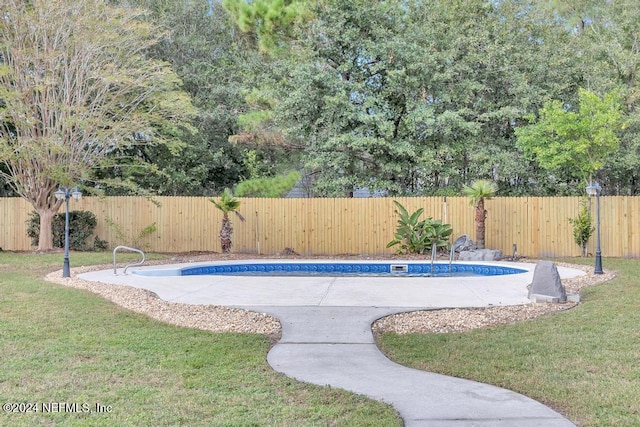 view of swimming pool featuring a yard