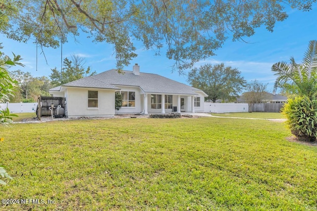 rear view of house featuring a lawn