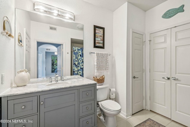 bathroom featuring vanity, toilet, and tile patterned flooring