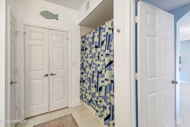 bathroom featuring walk in shower and tile patterned flooring