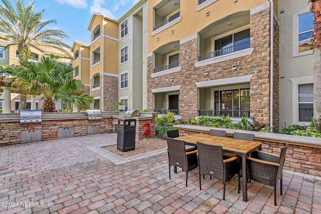 view of patio featuring exterior kitchen, a grill, and a balcony