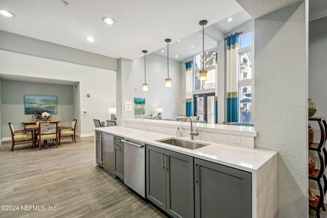 kitchen with gray cabinetry, sink, dishwasher, light hardwood / wood-style floors, and pendant lighting