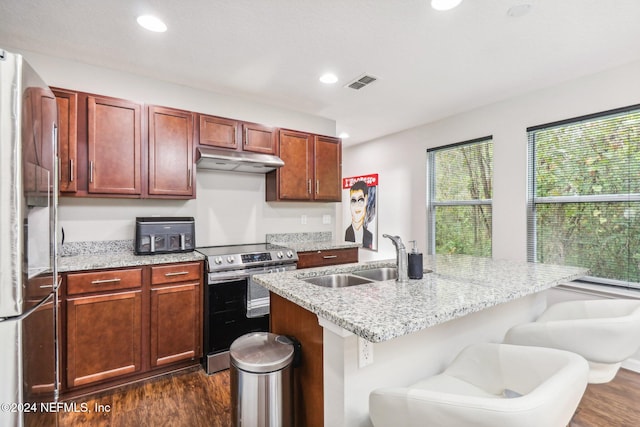 kitchen with a breakfast bar area, a center island with sink, sink, and appliances with stainless steel finishes