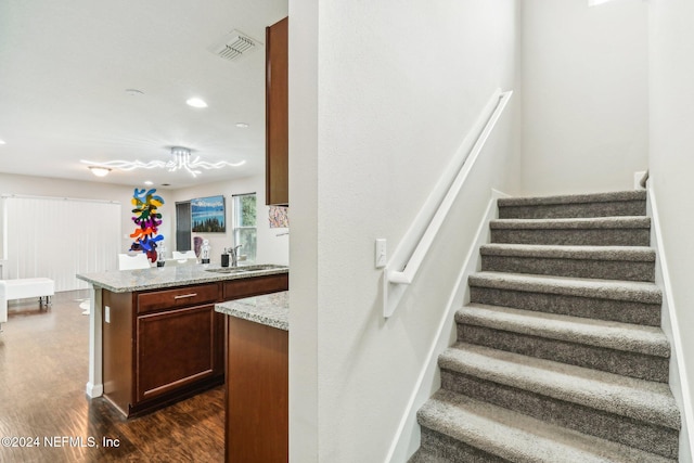 stairs featuring hardwood / wood-style floors and sink