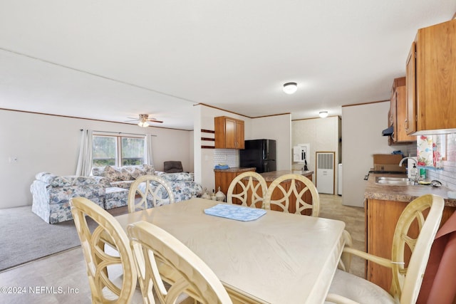 carpeted dining area with ceiling fan and sink