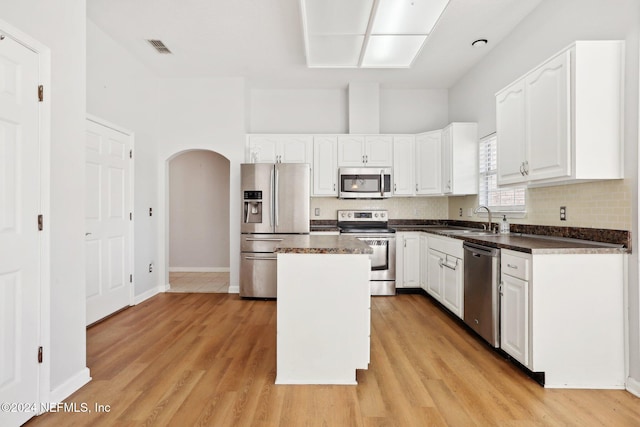 kitchen with white cabinetry, light hardwood / wood-style floors, appliances with stainless steel finishes, and a kitchen island