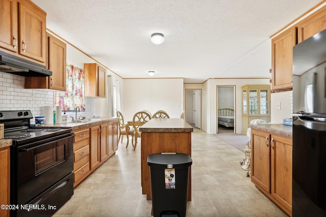 kitchen with black electric range, tasteful backsplash, sink, a kitchen island, and stainless steel refrigerator