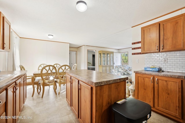 kitchen featuring a kitchen island, decorative backsplash, and a textured ceiling