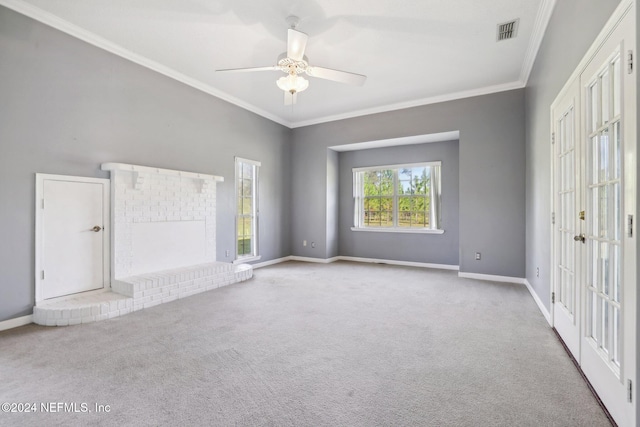 unfurnished living room featuring light carpet, crown molding, a brick fireplace, and ceiling fan