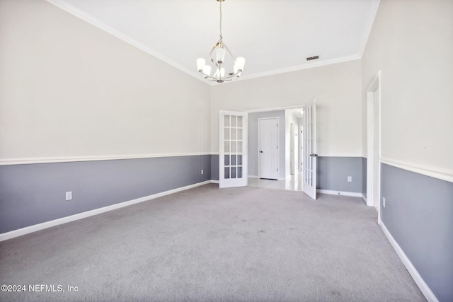 spare room with light colored carpet, french doors, ornamental molding, and a chandelier