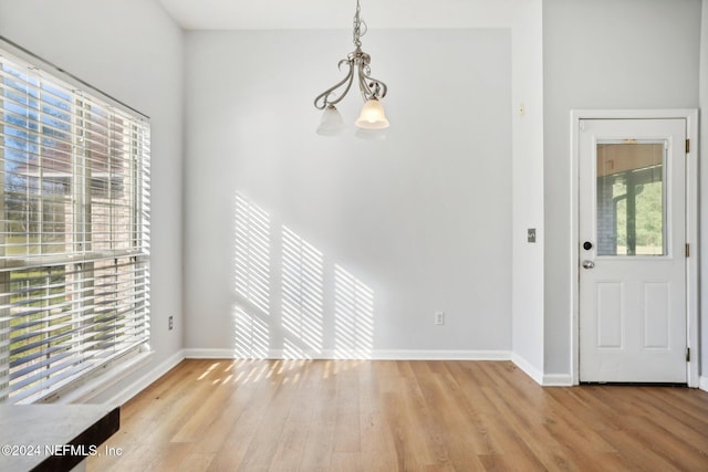 foyer entrance featuring light hardwood / wood-style floors, a chandelier, and a wealth of natural light