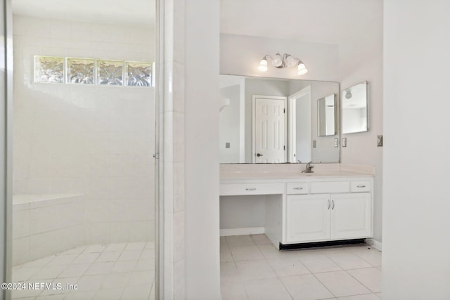 bathroom with vanity, tile patterned flooring, and tiled shower